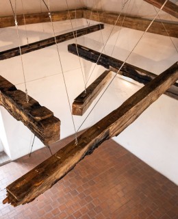 Memento z ohořelých trámů - dílo s autentickými trámy z budov zasažených náletem